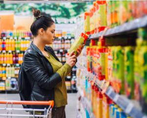 woman grocery shops, looks at drink label
